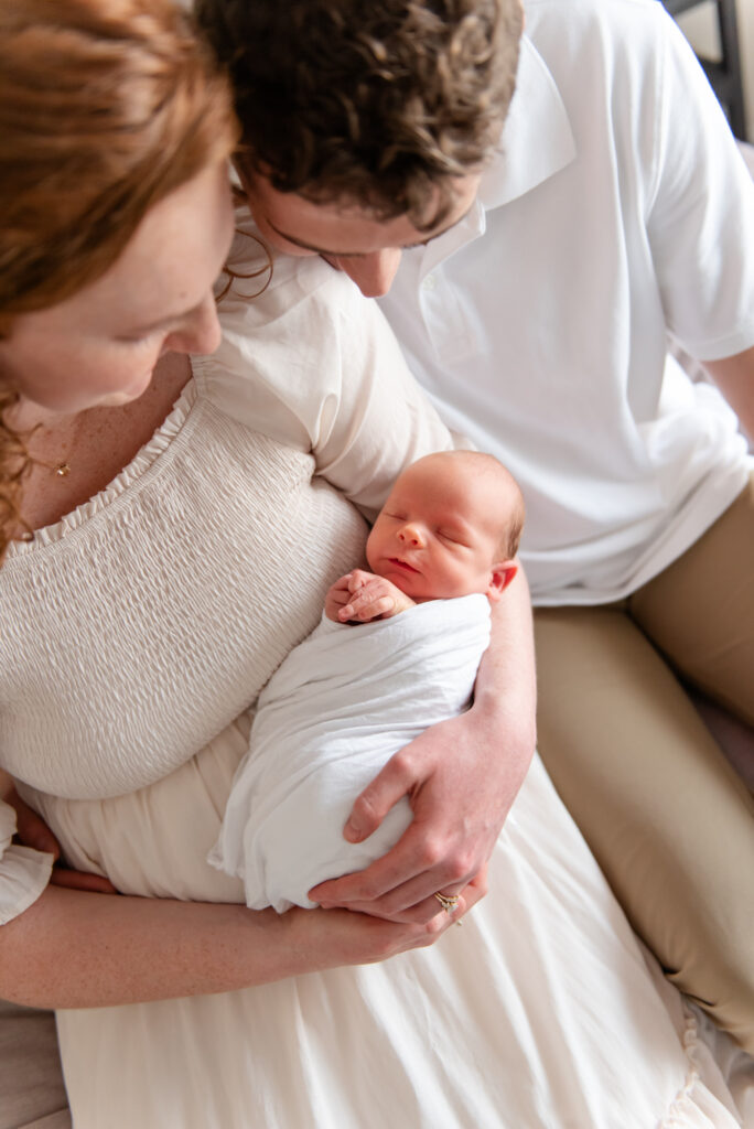 Parents lovingly looking at newborn during heartfelt in-home newborn session in St. George
