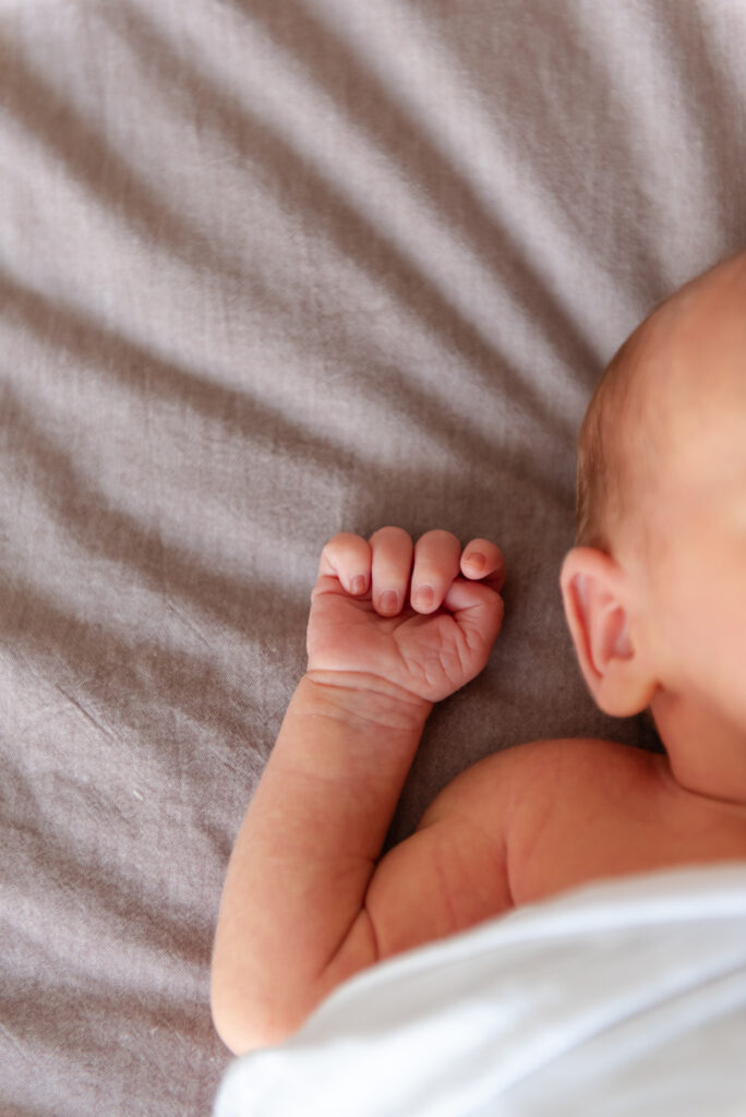 Close-up of newborn baby’s tiny fingers during in-home photo session in St. George, Utah