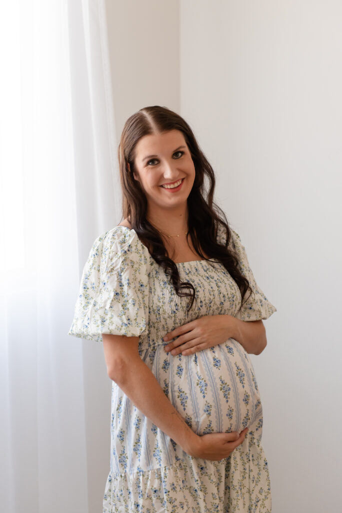 Maternity photography in Hurricane Utah – mom in glowing dress holding baby bump at The Studio Hurricane