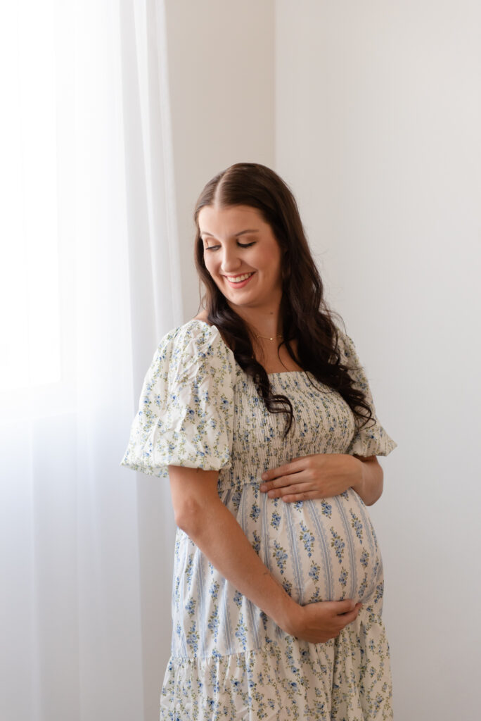 Maternity photography in Hurricane Utah – mom in glowing dress holding baby bump at The Studio Hurricane