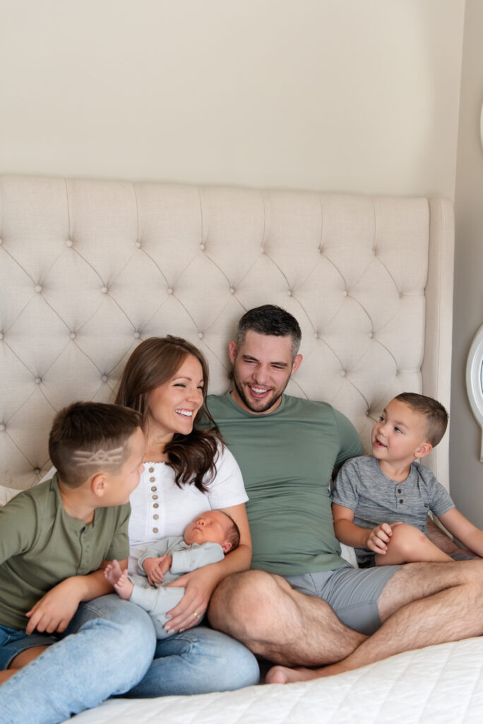 Family of 5 cuddled on bed