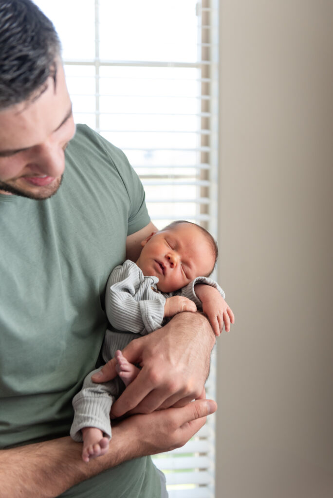 Newborn baby sleeping in dads arms in St. George, Utah