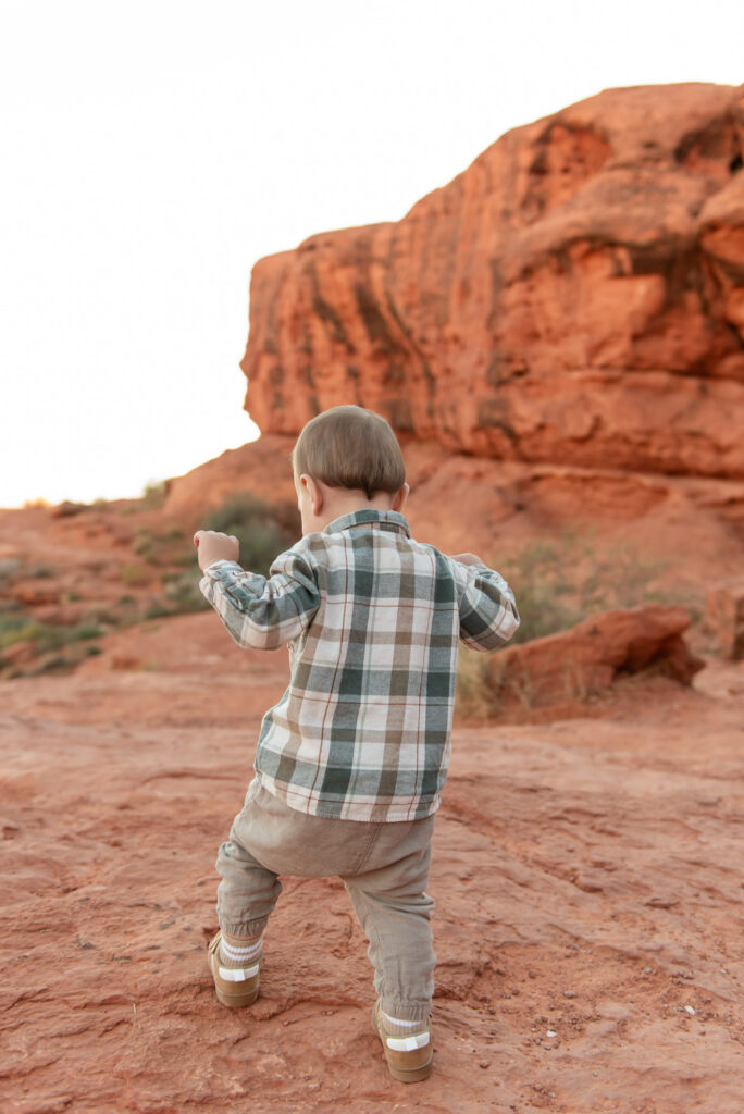 Toddler exploring red rocks at Pioneer Park