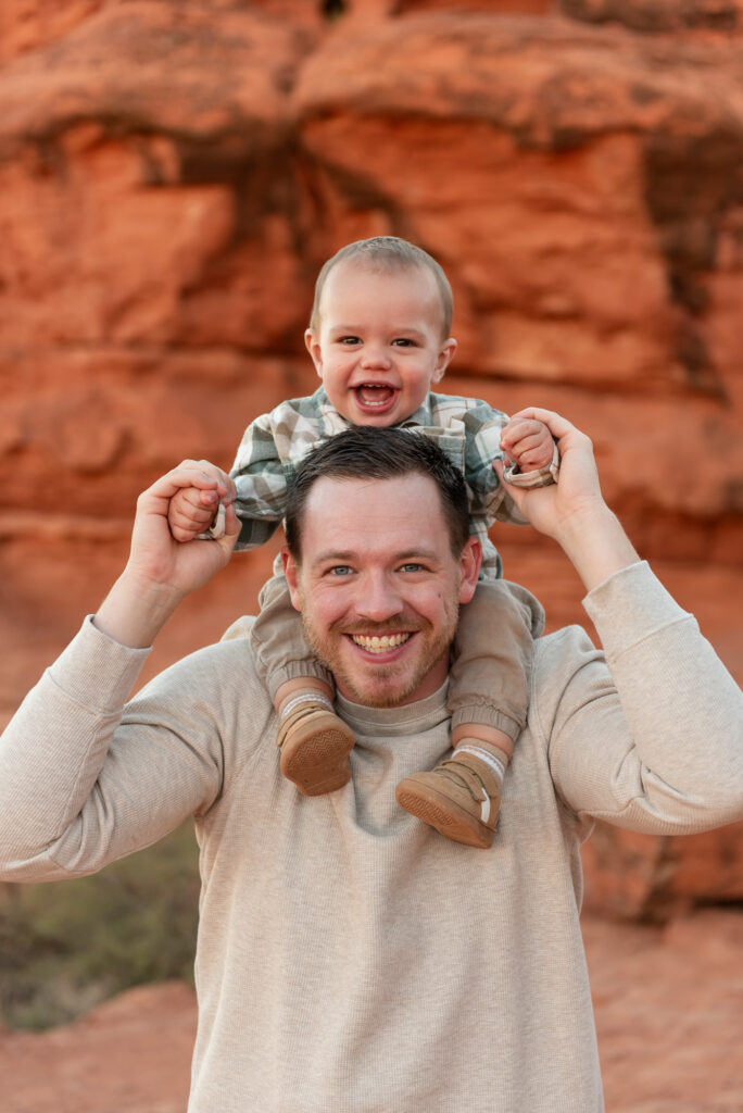 Toddler on dads shoulders during red rock family photos