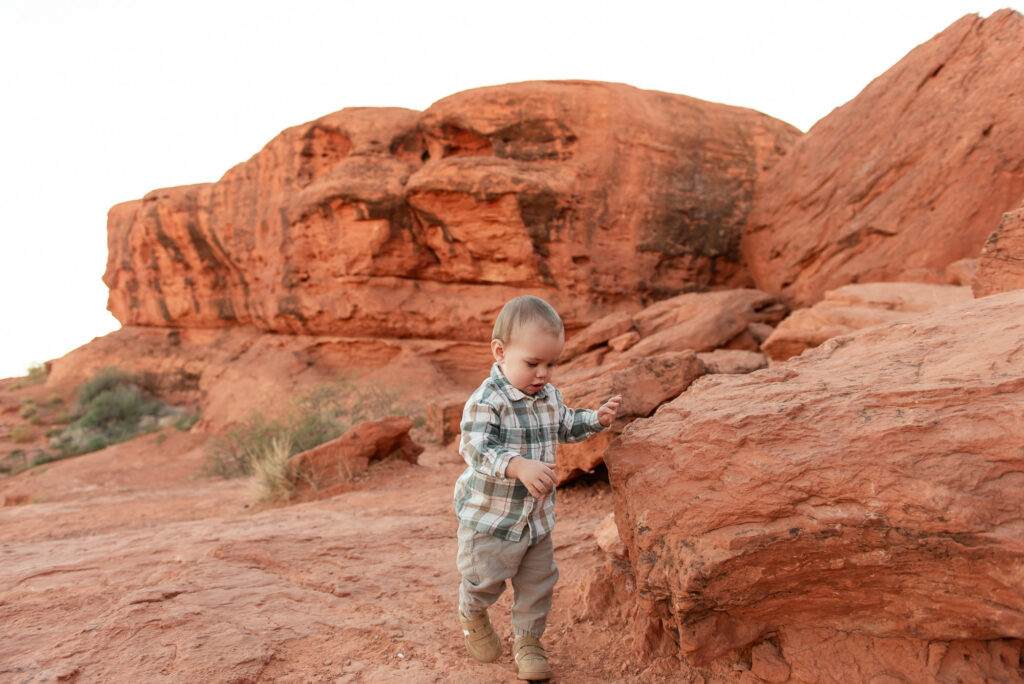 Toddler walking on red rocks