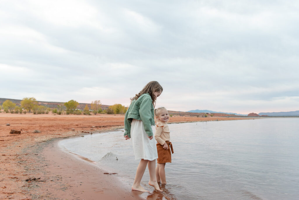 Sisters dipping toes in water at Sand Hollow